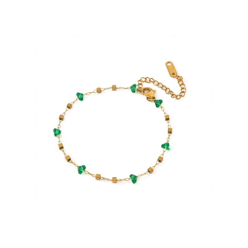A delicate gold-tone chain bracelet featuring alternating small green heart-shaped beads and tiny golden cubes, laid flat against a white background.