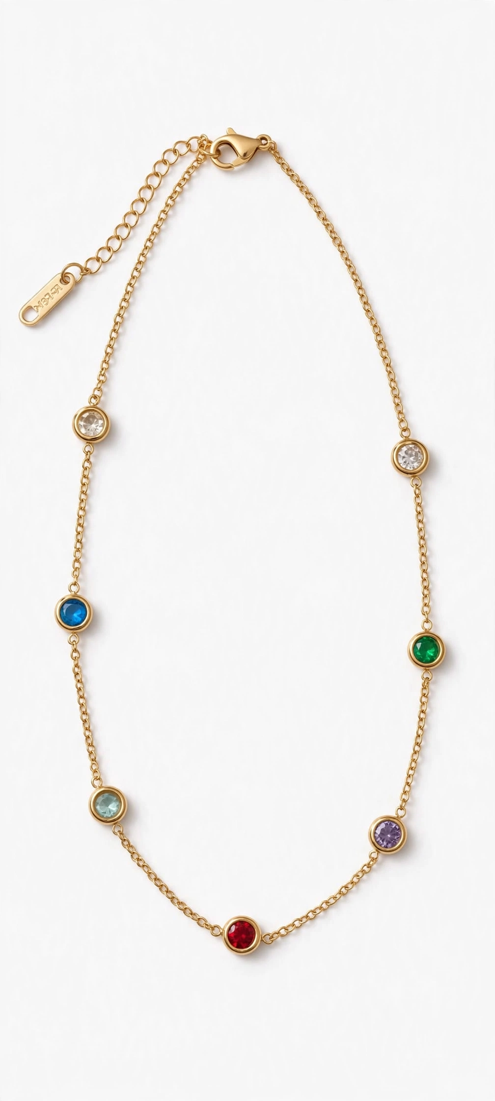 Gold plated station chain with bezel set colorful gemstones including red blue green purple and clear crystals on white background